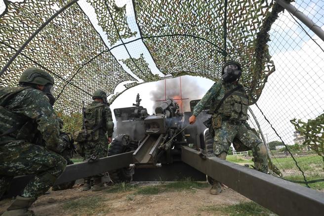  在毒气状况中，官兵戴上防护面具并实施射击任务。（记者黄迪明摄）