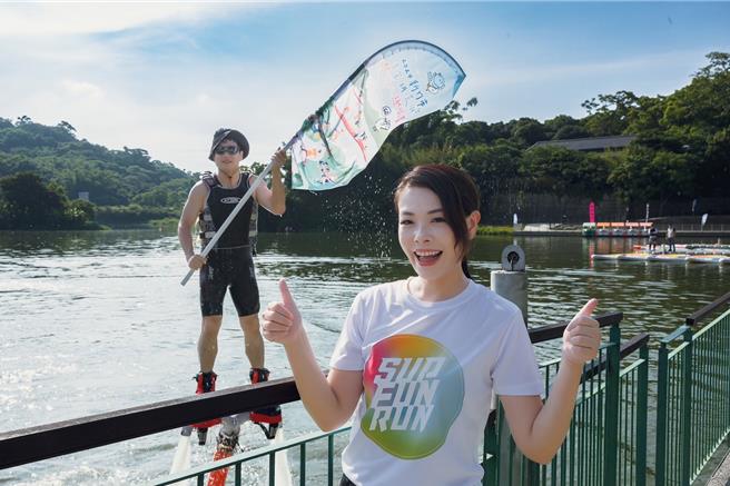 副市長邱臣遠（後）今天特別扮演神祕嘉賓，穿戴水上鋼鐵人設備，於湖面凌空飛起、化身水上英雄與市長高虹安合照。（新竹市政府提供／陳育賢新竹傳真）