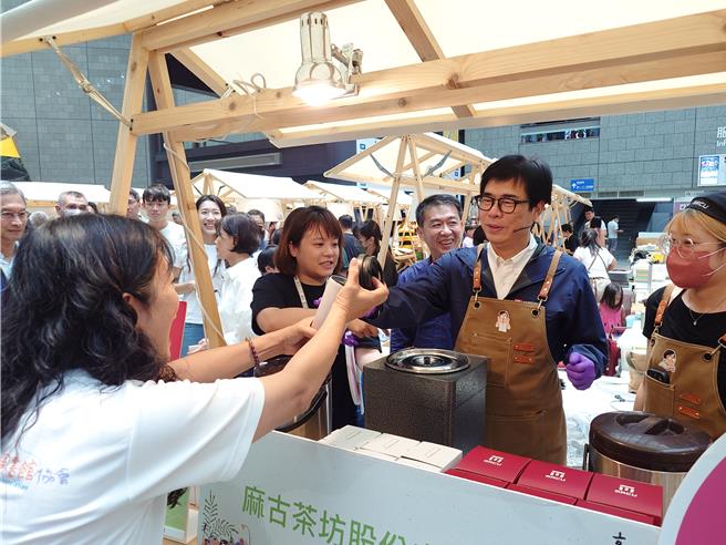 高雄市长陈其迈出席活动为使用环保杯民眾送上饮品，指出民眾消费习惯才是引领产业朝净零发展的关键。（任义宇摄）