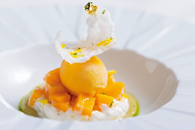 A CUT牛排館夏季新甜點「芒果糯米飯」，以義大利陳米Acquerello搭配椰漿與鮮奶製成米布丁，搭配愛文芒果和芒果雪酪，薑汁凝露與茵陳蒿油增添草本柑橘香，呈現泰式熱帶風情。圖／A CUT  STEAKHOUSE