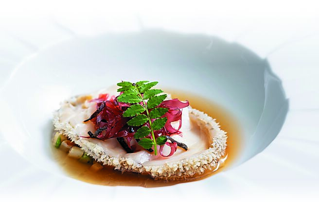 A CUT牛排館夏日新菜「南非鮑魚」，以日式佃煮烹調，搭配飛驒實山椒與炭烤魷魚，昆布蛤蠣竹筍高湯佐時令竹筍與蘆筍，呈現夏季鮮味。圖／A CUT  STEAKHOUSE