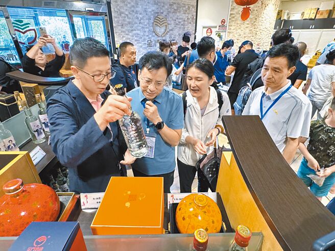 金门县府秘书王中圣（前左一）向福建省体育局长叶得盛（前右一）与厦门体育局长阮敦梁（前左二）介绍金门高粱酒。（于家麒摄）【饮酒过量 有害健康】