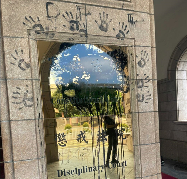 宪法法庭及惩戒法庭衔牌20日下午遭人泼黑漆，似对时事表达不满。犯事的田山盛国今则亲曝理由。（图／警方提供）