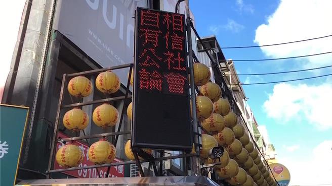 基隆廟口夜市的電子看板出現疑似力挺基隆市長謝國樑的文字，引發民眾議論。（張志康攝）