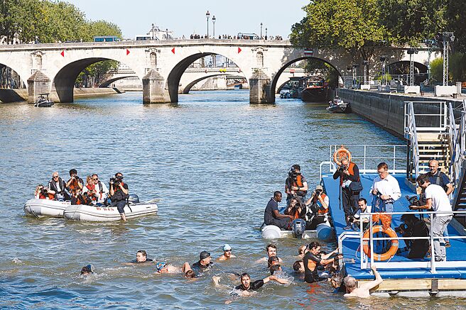 法国总统马克宏承诺会跳塞纳河游泳，但不一定会在奥运前。图为正在塞纳河戏水的民眾。（路透）