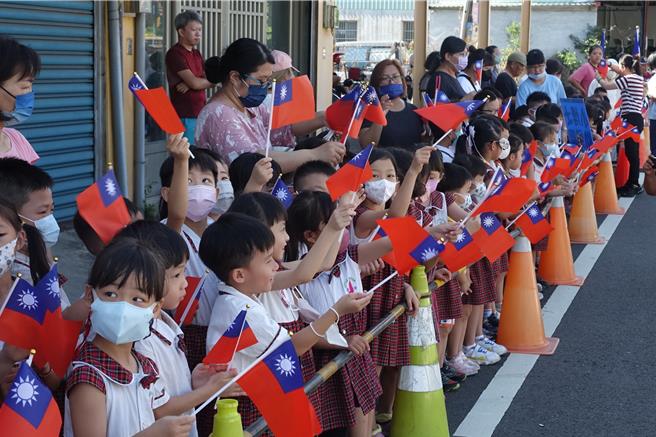 小朋友們揮舞國旗，開心為國軍加油。（羅琦文攝）