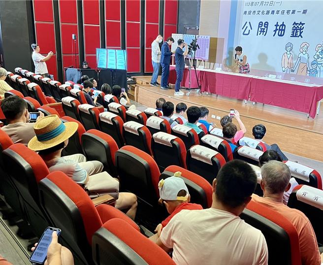 民眾帶著孩子至文化局圖書館7樓觀看南投市青年住宅第1期45戶公開抽籤過程，期盼能幸運抽中青宅。（楊靜茹攝）