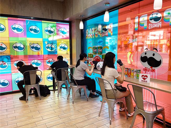 莱尔富「品客特色主题店」打造出舒适的超商休憩空间，橱窗贴上生动活泼的乐团与运动形象玻璃贴，传达品客活泼欢乐的品牌形象。（莱尔富提供／朱世凯台北传真）