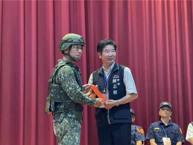 中部万安演习22日登场，台中市以大里、雾峰两区作为重点验证区，由统裁部副统裁官中将副司令陈忠文（左）致赠中市加菜金。（潘虹恩摄）