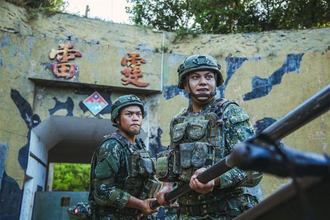 官兵手持洗把桿，將重達163公斤砲彈推進砲閂。（記者陳怡璿攝）