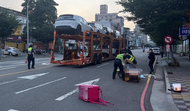 23日清晨约5点多，台中李姓外送员骑车行经南屯区永春东一路时，与赵姓男子驾驶、载满新车的大型拖板车发生碰撞。（民眾提供）