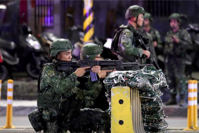 宪兵指挥部官兵23日凌晨在横跨新店溪的华翠桥实施「桥梁检管暨错假讯息处置」的演练，官兵持枪守备。（黄世麒摄）
