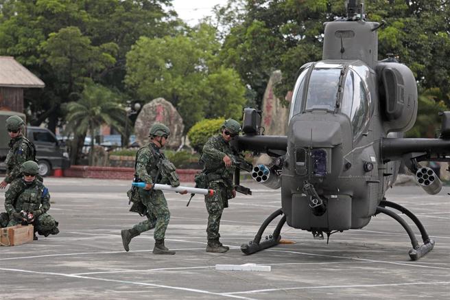 官兵手持海神火箭彈，迅速完成AH-1W攻擊直升機的掛彈作業。（記者簡廷哲攝）
