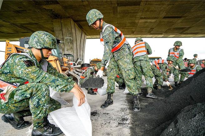 国防部指出，国军已完成整备，可随时依令投入灾害防救任务。图为国军昔于强颱尼伯特逼近时，协助堆沙包。（本报资料照片）