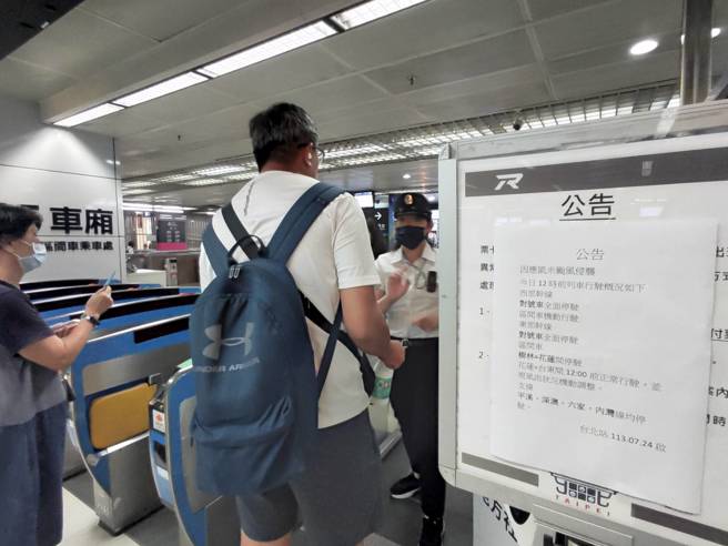 受到颱風凱米來襲影響，台鐵公司貼出西部幹線、東部幹線、南迴線中午12時前停駛的公告，站務人員向旅客說明車班是否有停駛等問題。（劉宗龍攝）