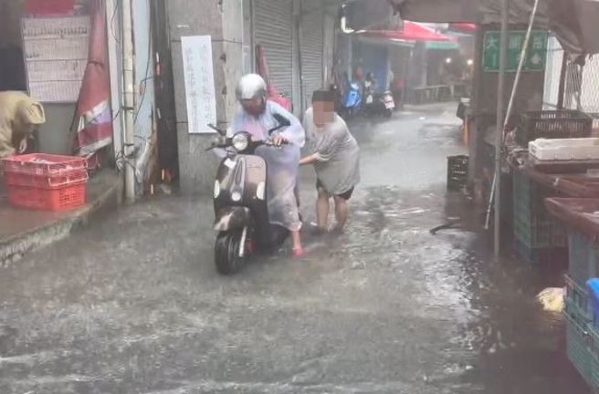 高雄旗津今天颱風加上年度大潮淹水，機車騎不動。（翻攝自記者爆料網）