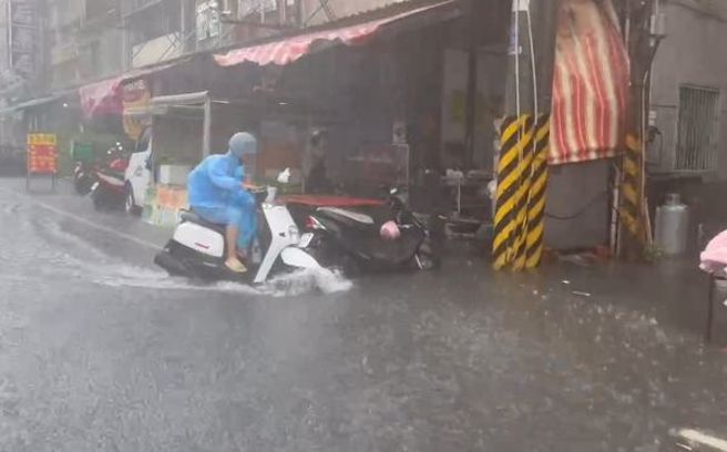 高雄旗津淹水，騎機車像在衝浪。（翻攝自記者爆料網）