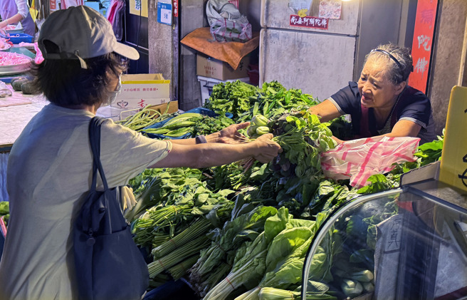 受到凱米颱風進逼影響，台北市場蔬菜批發價23日時達每公斤44.1元，未料宣布停班停課的24日菜價卻不漲反跌至每公斤37.6元。凱米颱風24日逼近台灣，民眾前往購買蔬果青菜以備生活所需。（姚志平攝） 