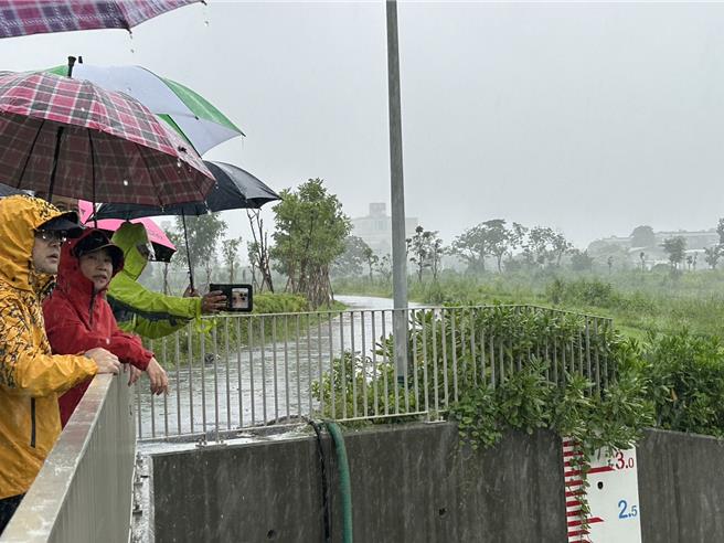 强颱凯米来袭，屏东县24日上午10时许过后风雨渐强，县长周春米稍早至大仁滞洪池视察。（谢佳潾摄）