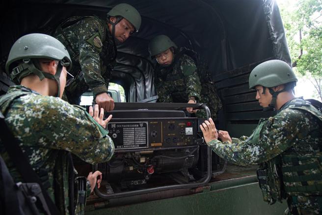 陆军52工兵群官兵将发电机放置于3.5吨载重车，待命投入灾防任务。（第5作战区提供）