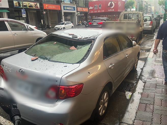 高雄三民区一辆停放路边轿车，今天遭一旁大楼受颱风影响所剥落磁砖砸中，车顶凹一个大洞。（民眾提供／任义宇高雄传真）