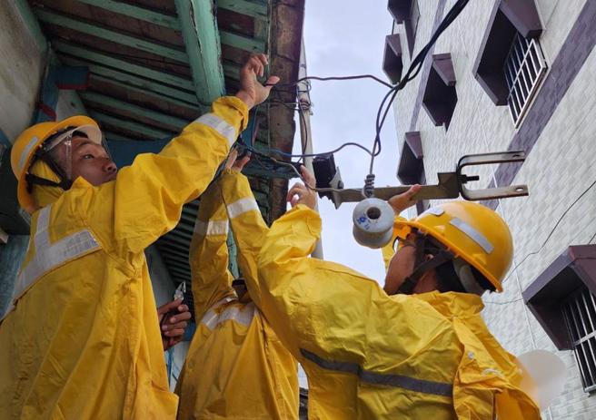 台電人員風雨中搶修，爭取於最短時間內復電。（台電新營區營業處提供／張毓翎台南傳真）