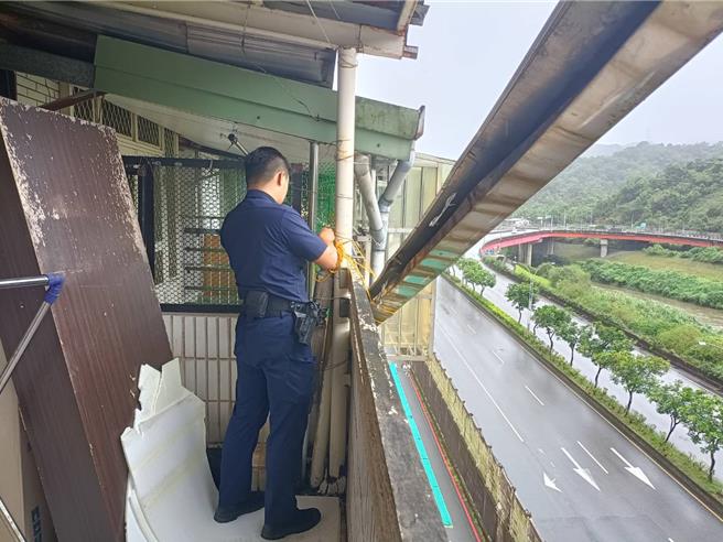 基隆市七堵區的百一街一處5樓民宅鐵皮屋簷因強風吹襲而鬆脫相當危險。警方到場協助固定並通知工務處派員處理，最後順利拆除，未造成人車損傷。（基隆市警察局提供／徐佑昇基隆傳真）