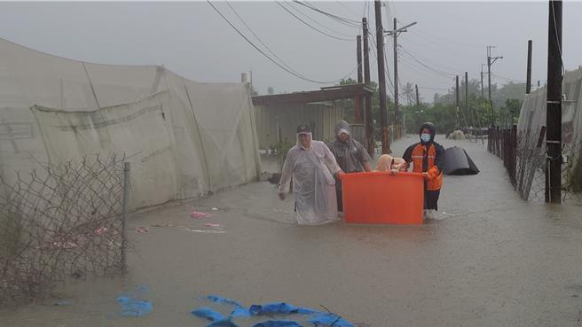 屏东县里港乡西隆路段水淹及膝，警消急中生智让受困人员乘坐在大水通中，以便救援。（屏东消防局提供／谢佳潾屏东传真）