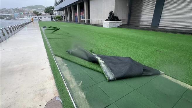 基隆市文化中心前廣場的人工草皮也遭強吹刮得掀起。（張志康攝）