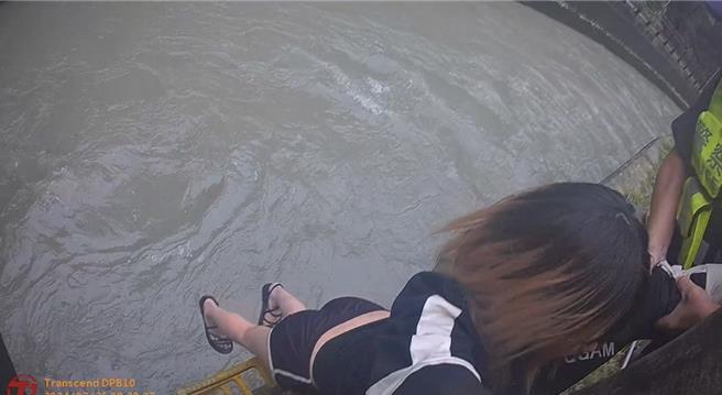 女子负气离家夸坐湍急大圳旁，员警即时发现并上前救援安抚。(平镇分局提供／廖姮玥传真）