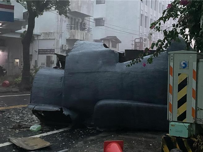 花蓮軒轅路上一間咖啡店樓頂的裝置藝術「巨型摩艾像」被強風吹落，躺倒馬路中央。（里長張東耀提供）