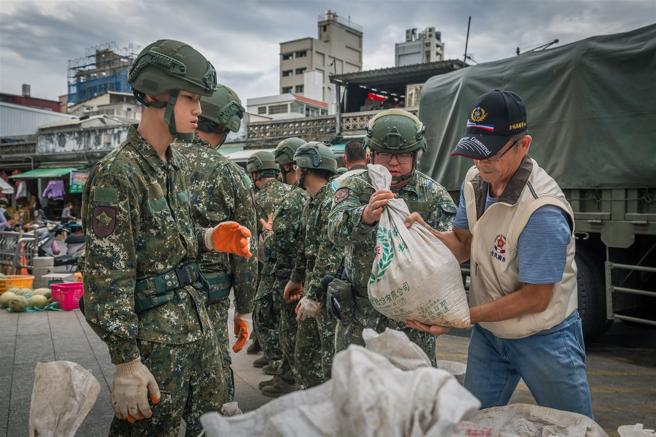 官兵與後輔幹部一同搬運沙包，攜手共護家鄉安全。（記者陳怡璿攝）