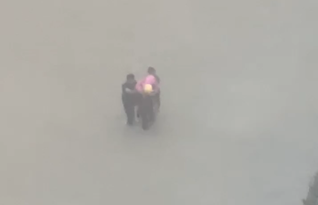 爱河溢堤强灌社区 ，勇消在美术馆特区「半游泳」救灾。(翻摄自记者爆料网)