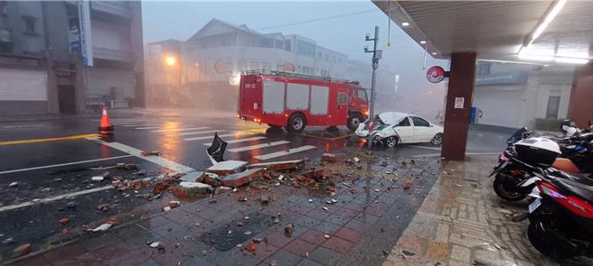 蓮市中興路1棟5層樓建物女兒牆，24日疑遭狂風掀起的頂樓鐵皮推倒，直接重砸停在路邊的車輛，造成後座母子1死1重傷。花蓮縣政府將調閱建物原始圖，確認該牆是否屬違章建築，釐清相關責任。（花蓮縣消防局提供／羅亦晽花蓮傳真）