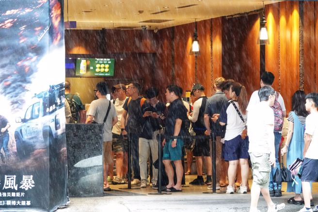大台北今天風雨比預估來得小，民眾賺到1天颱風假，台北市西門町的電影院外出現民眾排隊等候購票的人潮。（黃世麒攝）
