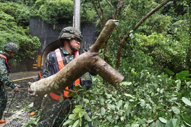 官兵徒手移除断枝，协助民眾儘早恢復生活。（记者黄迪明摄）