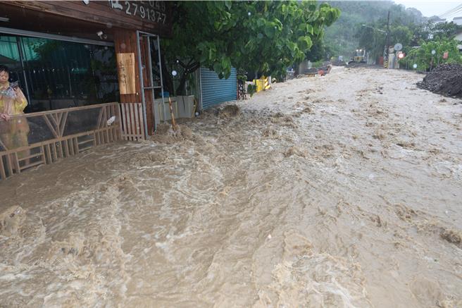 受凯米颱风影响，台21线位于南投县信义乡入口处的明德路段，因野溪暴涨挟带大量土石向下而流，路面被淹没导致交通受阻，水流顺坡度流入路旁民宅，民眾无奈叫苦。（南投县府提供／潘虹恩南投传真）