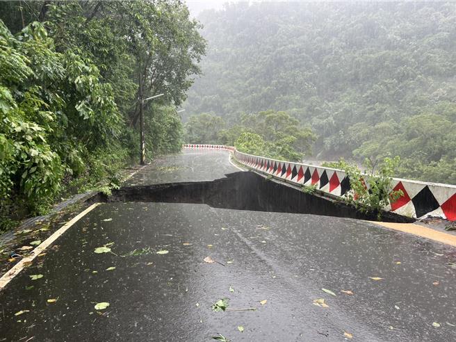 南投县信义乡双龙部落联外道路25日传出被大雨和溪水掏空，路面出现「天坑」，信义警分局前往拉起警戒线，全线封闭，禁止车辆通行。（信义警分局提供／潘虹恩南投传真）