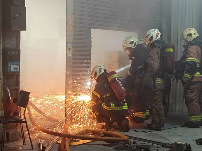 消防队获报到场破坏铁卷门进入抢救。（翻摄画面）