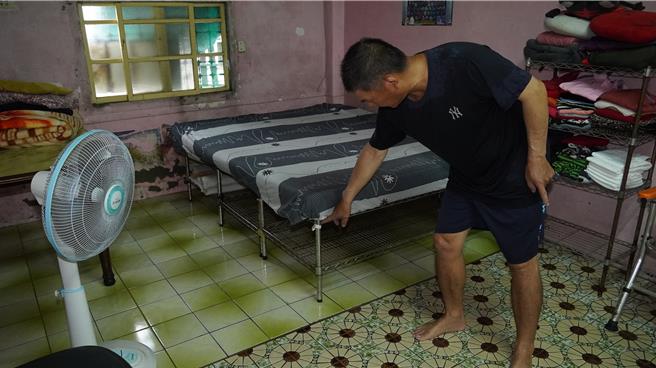 中榮里6鄰王先生25日見積水已達老母親床墊，連忙把母親強制帶離。（寶智華攝）