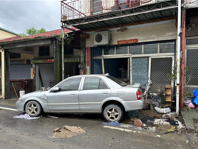 強颱凱米肆虐，屏東縣高樹鄉建興村慘遭水淹，村民停在家門口的汽車因遭水流沖歪往家裡方向撞，整扇門被撞壞，慘不忍睹。（謝佳潾攝＋