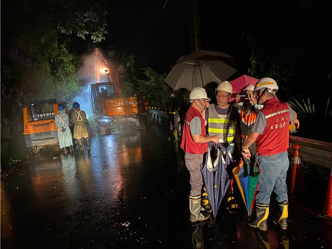 新北市團隊漏夜搶通三峽區北114線道1K處，養工處工務所主任陳正倫（右三）雖是肺腺癌晚期患者，昨晚仍冒著風雨和現地仍有落石的風險協助搶災。（新北市工務局提供）