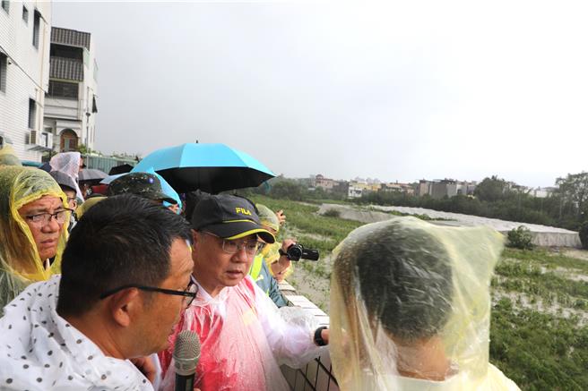 行政院長卓榮泰今天冒雨勘察八掌溪畔泡水的木瓜園。（廖素慧攝）