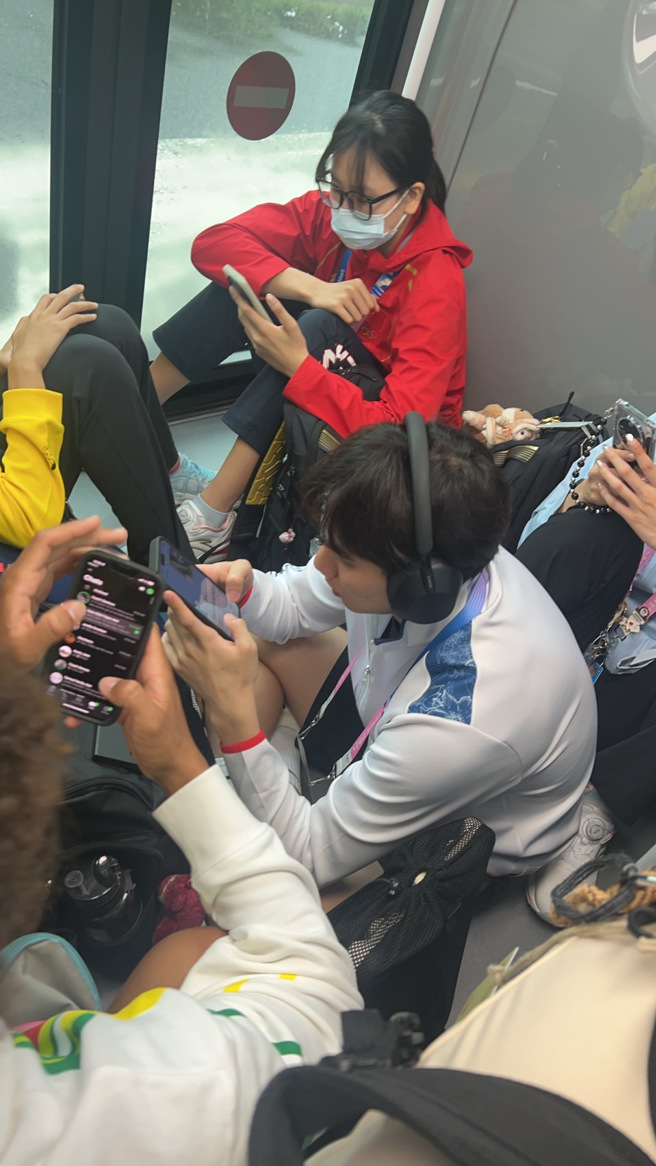 巴黎奥运选手接驳车人数爆满，「台湾蝶王」王冠闳与其他国选手都只能在车上席地而坐。（黄智勇提供）