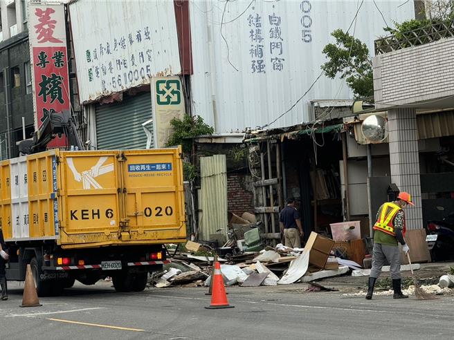 環保清潔人員一邊掃碎屑和樹葉另一邊清運大型圾垃。（洪靖宜攝）