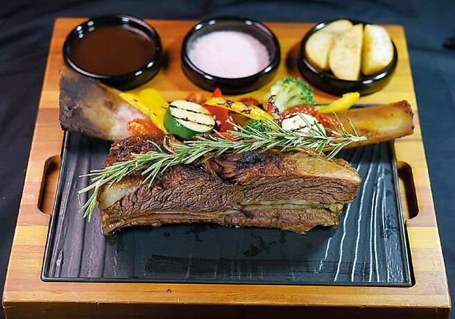 〈焰燒牛小排附烤時蔬〉以美國牛小排塗抹獨家醬汁提味，再與蔬菜、香料燜烤三小時至骨肉分離，非常「美」味。圖／姚舜