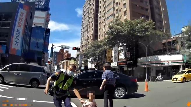 男童跟着阿公移事故车到路旁突嚎啕大哭，女警见状抱起安抚化解。（台中市第一警分局提供／李易昌台中传真）