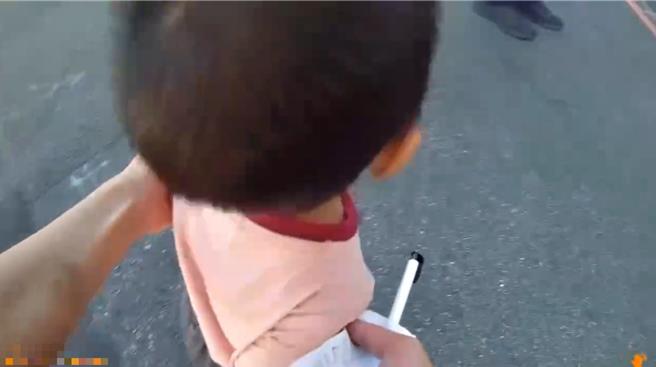 男童跟着阿公移事故车到路旁突嚎啕大哭，女警见状抱起安抚化解。（台中市第一警分局提供／李易昌台中传真）