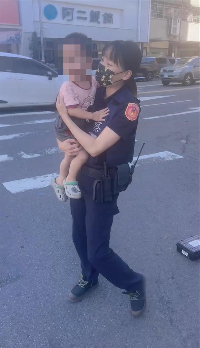 男童跟着阿公移事故车到路旁突嚎啕大哭，女警见状抱起安抚化解。（台中市第一警分局提供／李易昌台中传真）