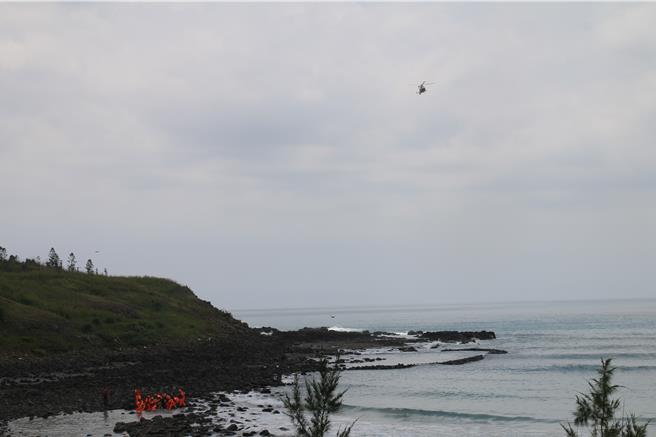2024年7月28日澎湖县／新北游客28日梦幻沙滩戏水，1男惨遭海流带走寻获已溺毙。图为安检与警消合力将寻获的李男以长背板抬上岸，直升机仍在盘旋搜寻。（许逸民摄）